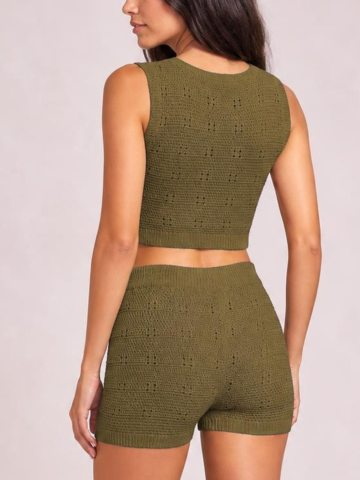 Back view of a model in an olive-green eyelet knit round-neck tank and matching high-waisted shorts with a fitted silhouette and ribbed hems.