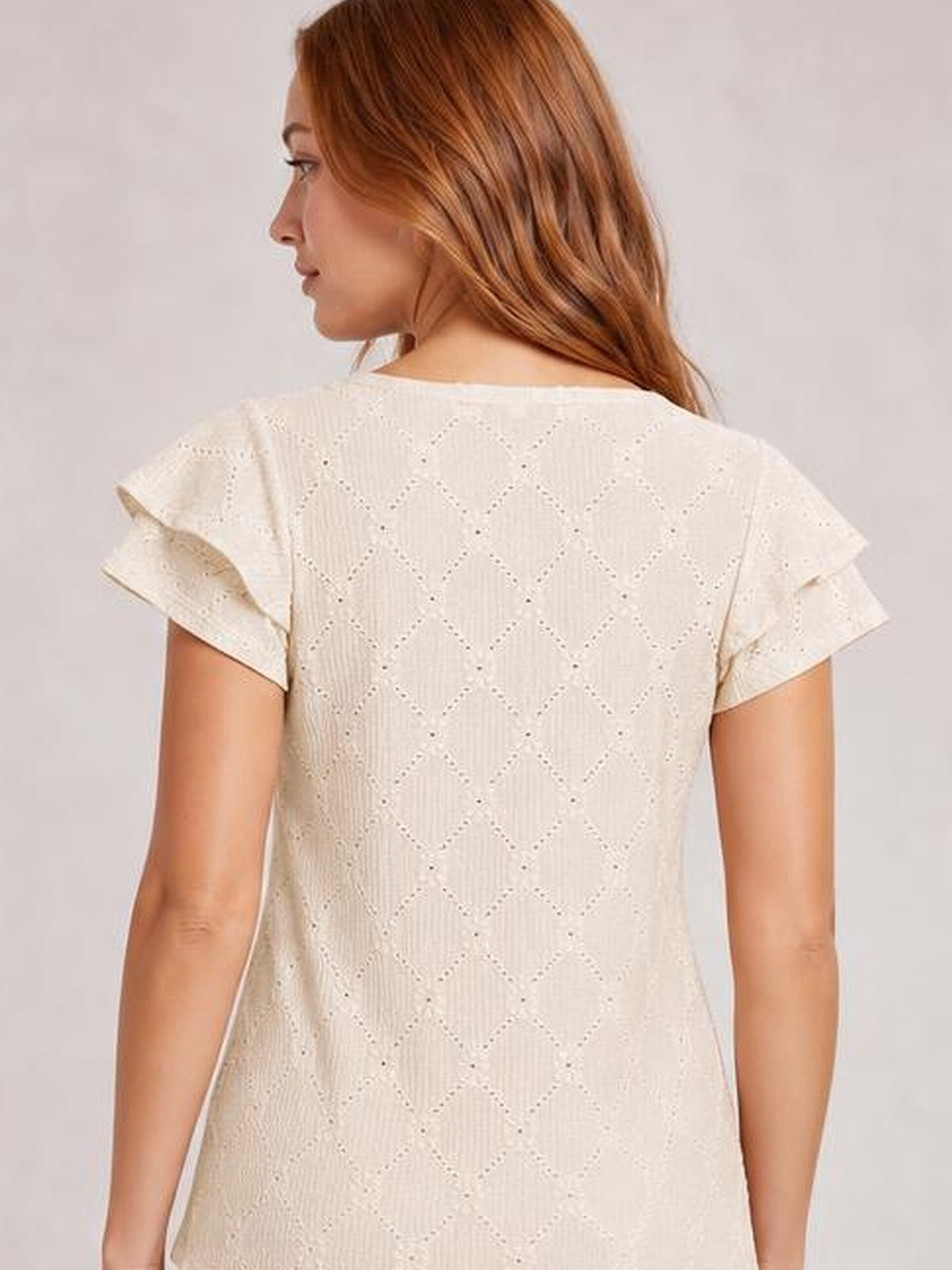 Model shown from behind wearing an ivory eyelet top with a diamond lace pattern, relaxed straight silhouette, and layered ruffled cap sleeves.