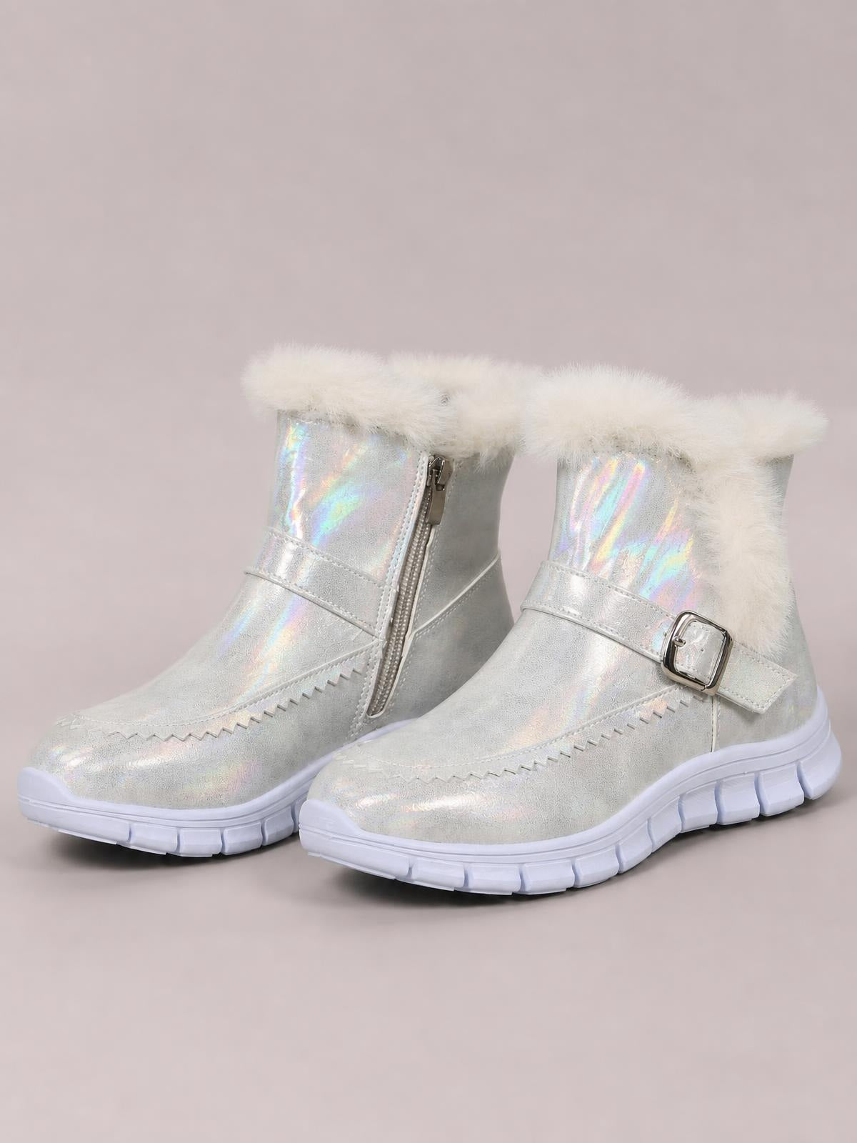Iridescent silver faux leather winter ankle boots feature fluffy faux fur cuffs, side zippers, buckled straps, and chunky flat rubber soles.