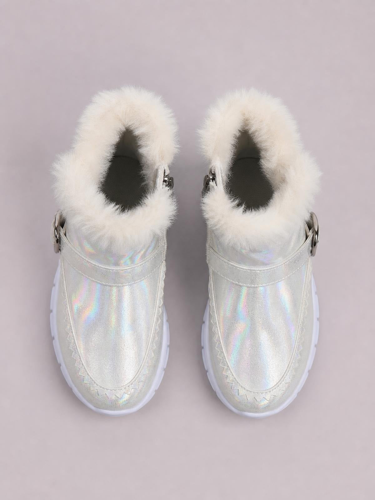 Iridescent silver winter ankle boots feature plush white faux fur lining, stitched panel construction, side straps, and flat white rubber soles.
