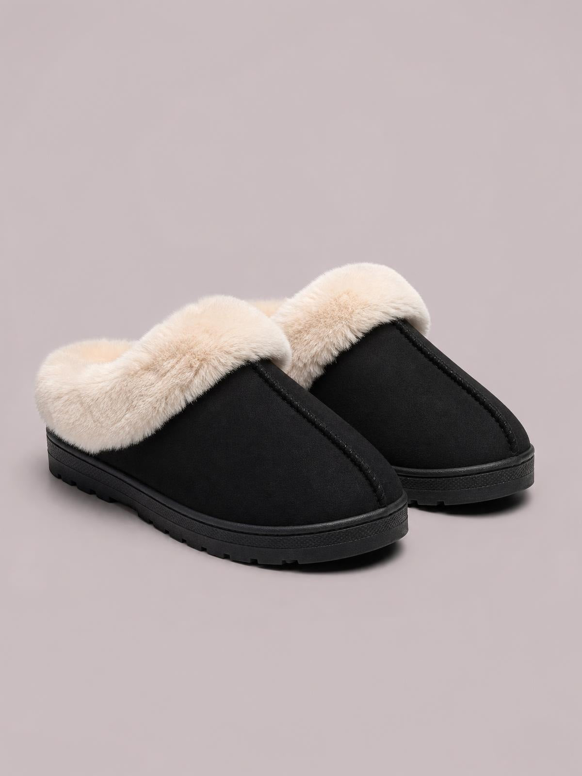 Black round-toe platform slippers with plush cream faux-fur uppers, stitched trim, slip-on design, and textured rubber soles.