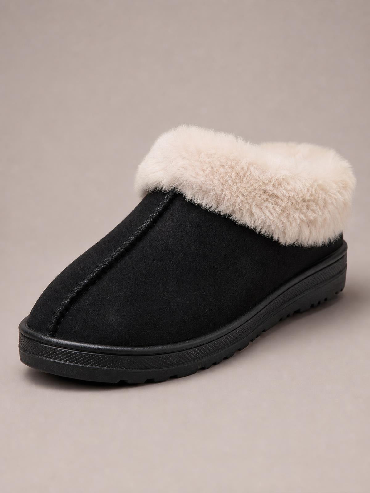 A black round-toe slipper features a plush faux-fur cuff, stitched center seam, suede-like upper, and thick rubber platform sole with textured tread.