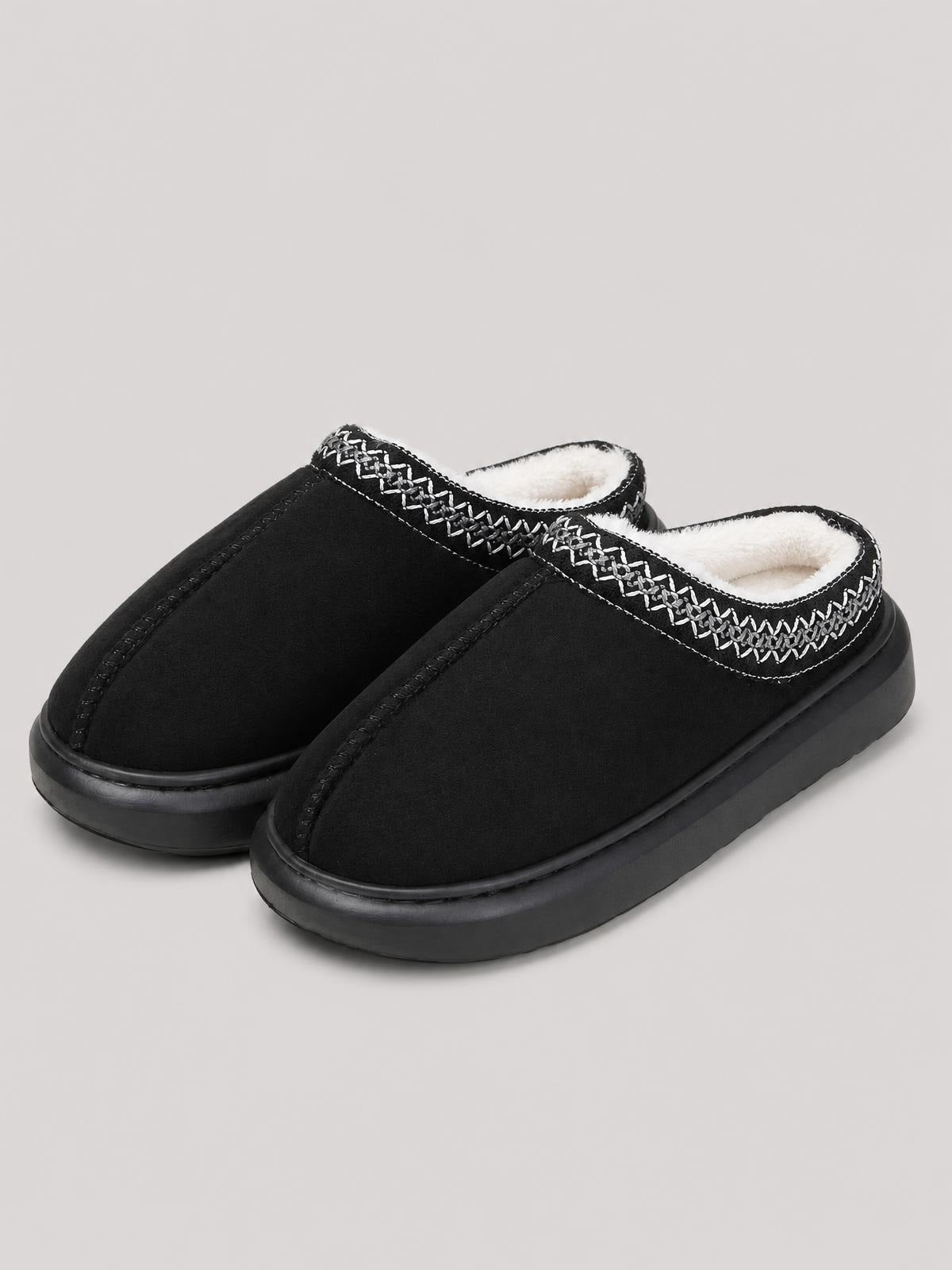 Black faux fur suede platform slippers feature a slip-on mule silhouette, plush white lining, decorative stitched trim, and thick black rubber soles.