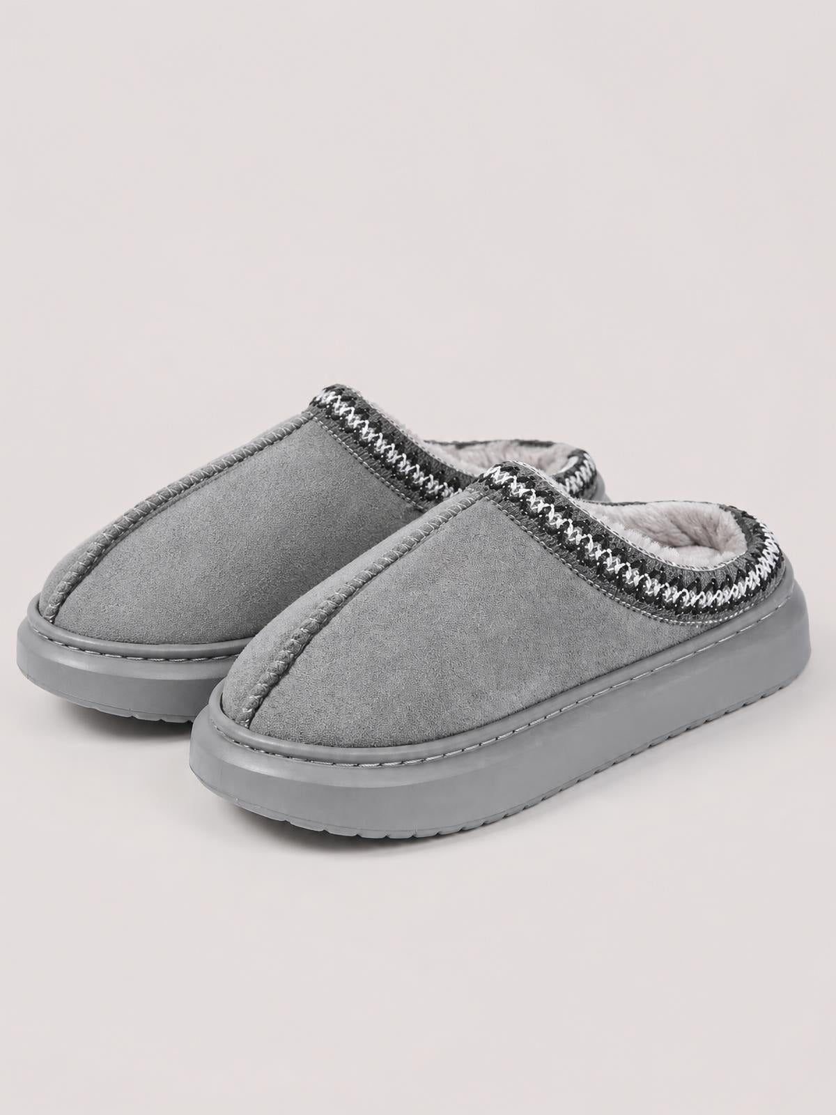 Gray suede platform slippers feature slip-on mule styling, soft faux fur lining, stitched trim, and thick flat rubber soles.