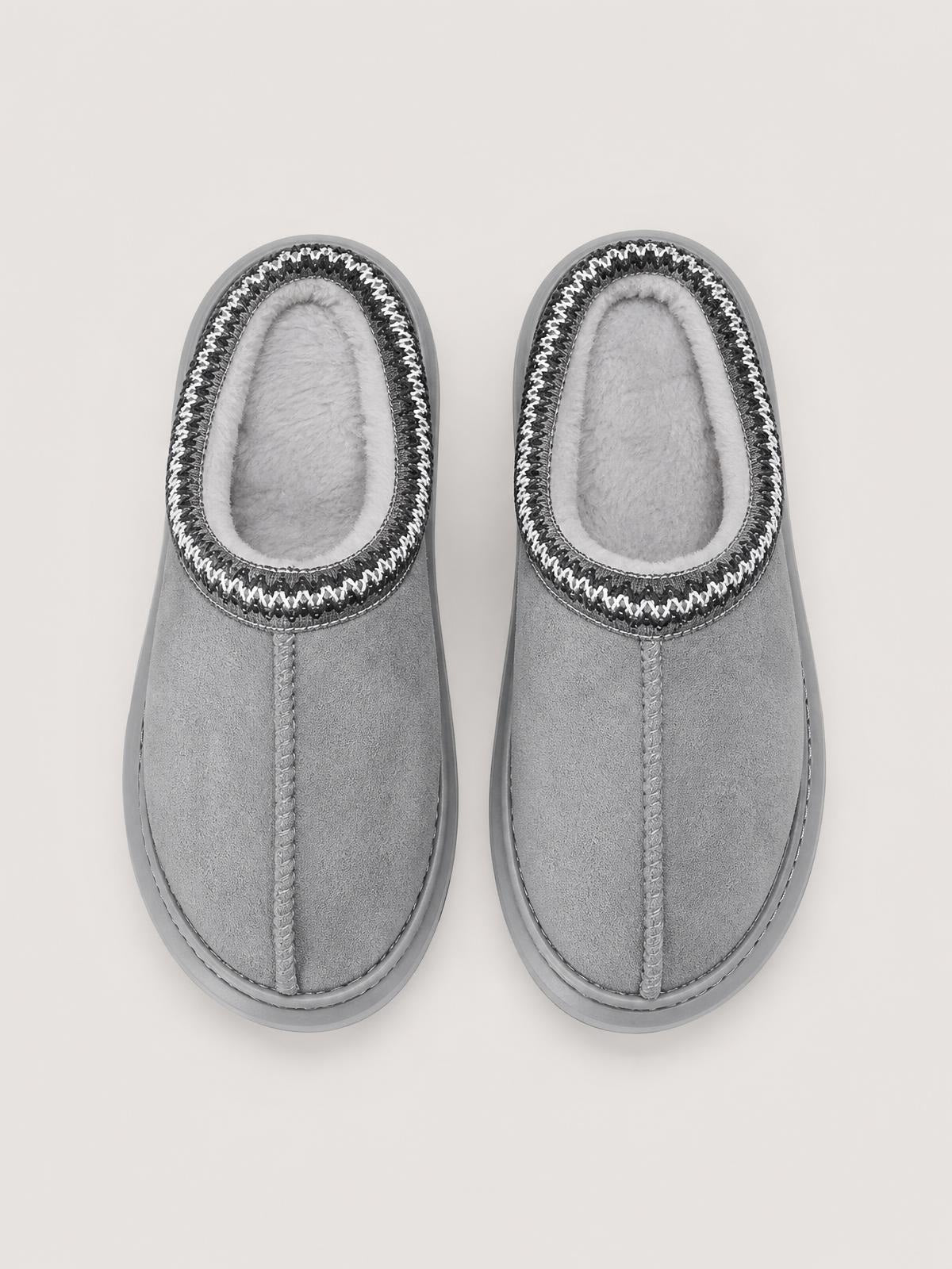 Pair of gray suede platform slippers with closed toes, plush faux fur lining, contrast stitched trim, center seam construction, and thick rubber soles.