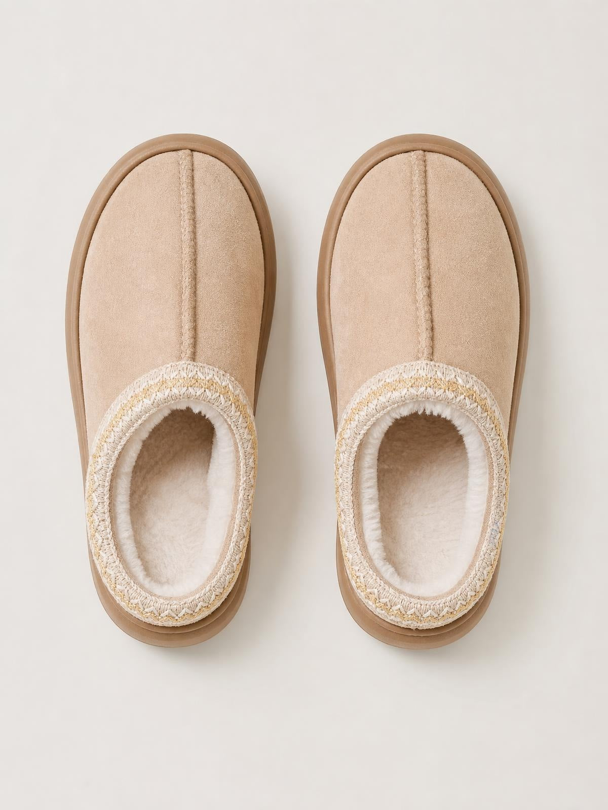 Pair of beige faux suede platform slippers with rounded toes, plush faux fur lining, woven trim, and thick rubber soles shown from above.