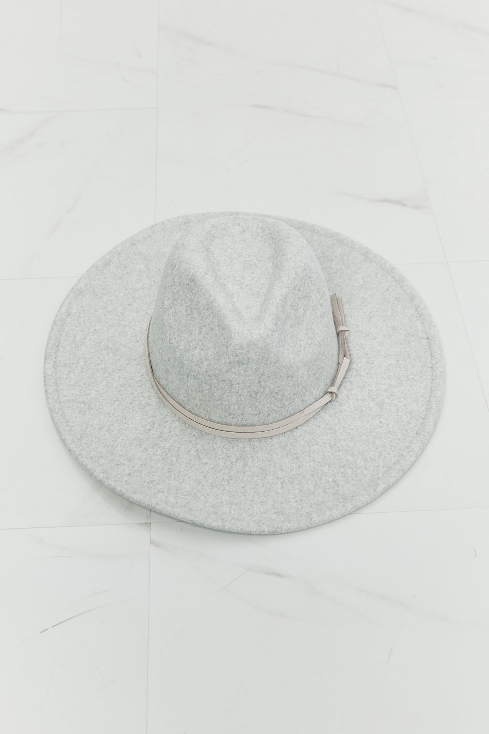 Light gray solid fedora hat with a structured crown, wide brim, and slim coordinating band finished with a small tie detail.