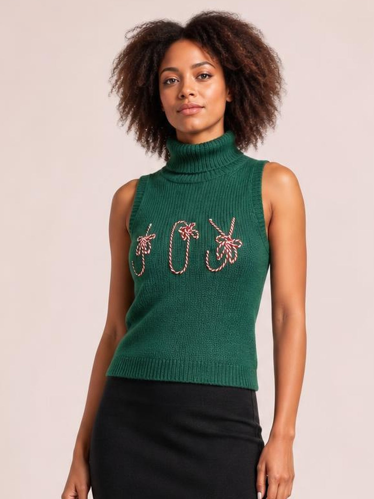 Model stands facing forward in a festive green ribbed turtleneck sweater vest with embroidered candy cane motifs, sleeveless construction, and a fitted silhouette.