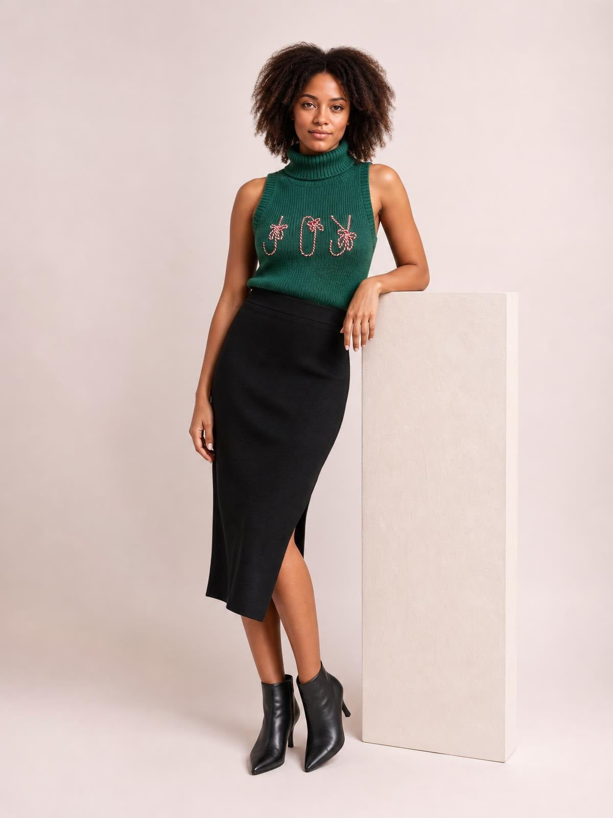 A model wears a green ribbed turtleneck sweater vest with festive embroidered candy cane motifs, a sleeveless fitted silhouette, and slight stretch.