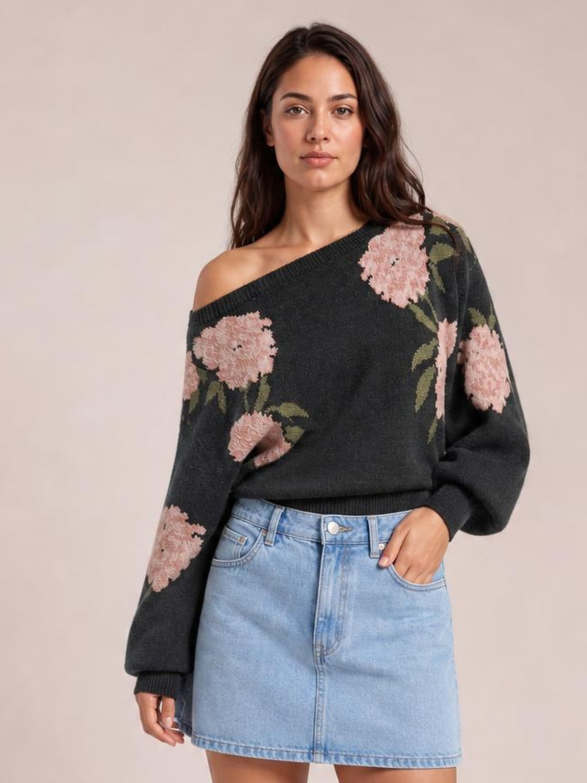 Model poses in a black floral sweater with a wide boat neckline, long sleeves, ribbed cuffs and hem, and a relaxed silhouette.