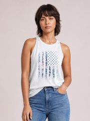 Model poses in a white sleeveless tank with a floral graphic, round Grecian-style neckline, regular relaxed silhouette, and one hand in her jeans pocket.