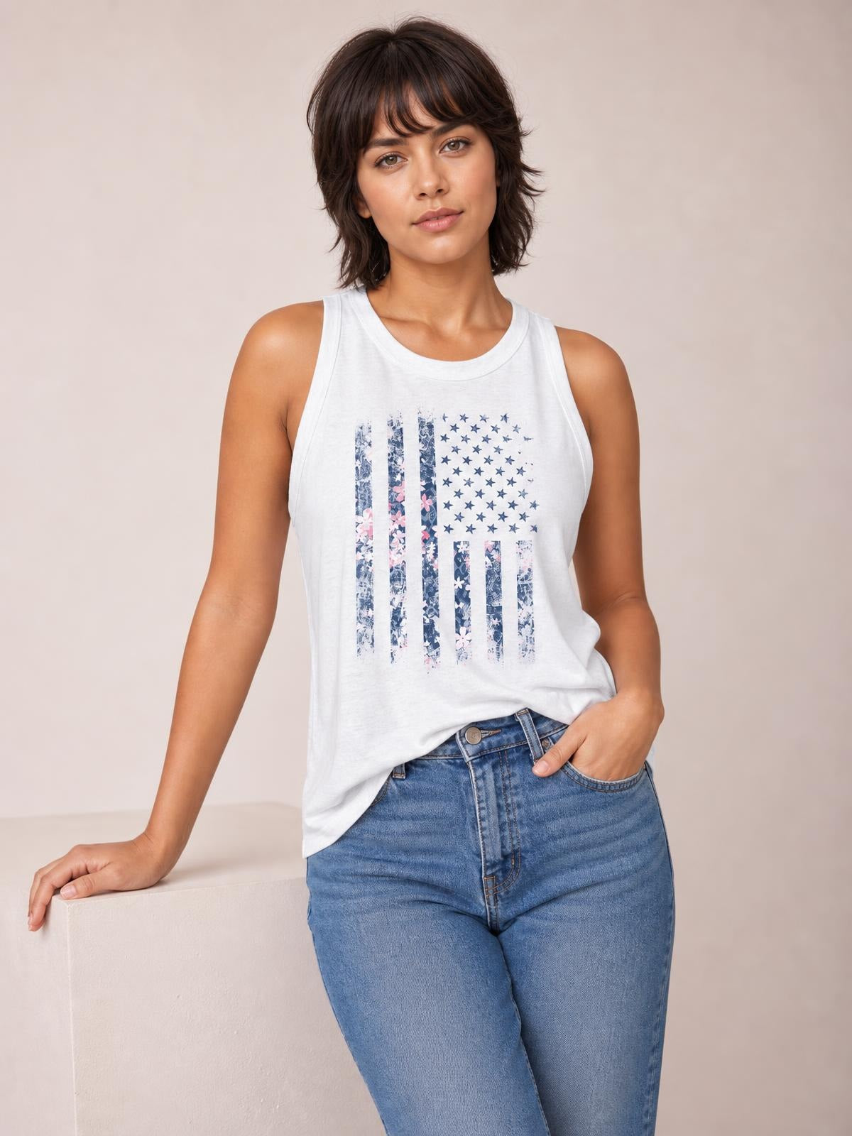 White sleeveless tank with a round neckline and floral graphic print, shown on a model in a relaxed pose with a regular-length silhouette.