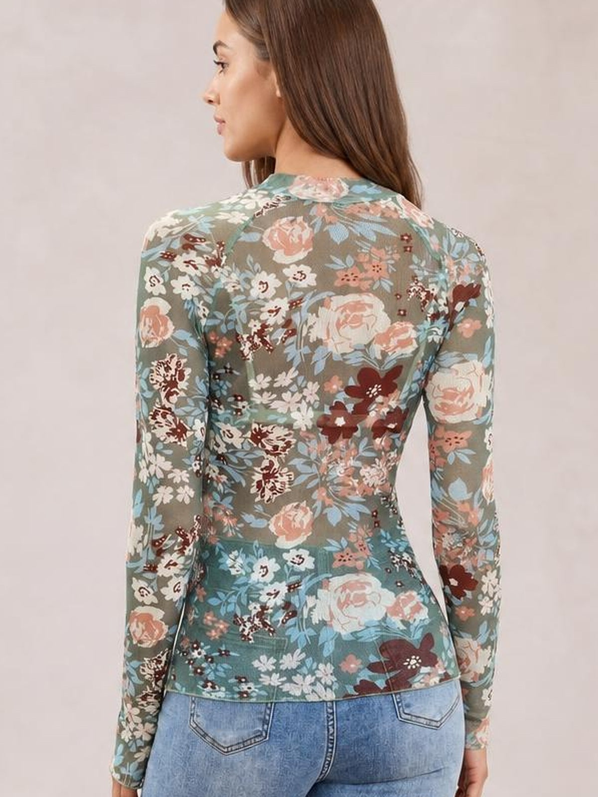 Model shown from the back wears a fitted floral mock neck long sleeve top in muted teal with pink, cream, blue, and burgundy flowers.