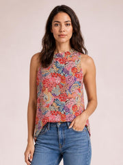 Model wearing a colorful floral print mock neck tank top with a sleeveless cut and relaxed regular-length silhouette, paired with jeans.