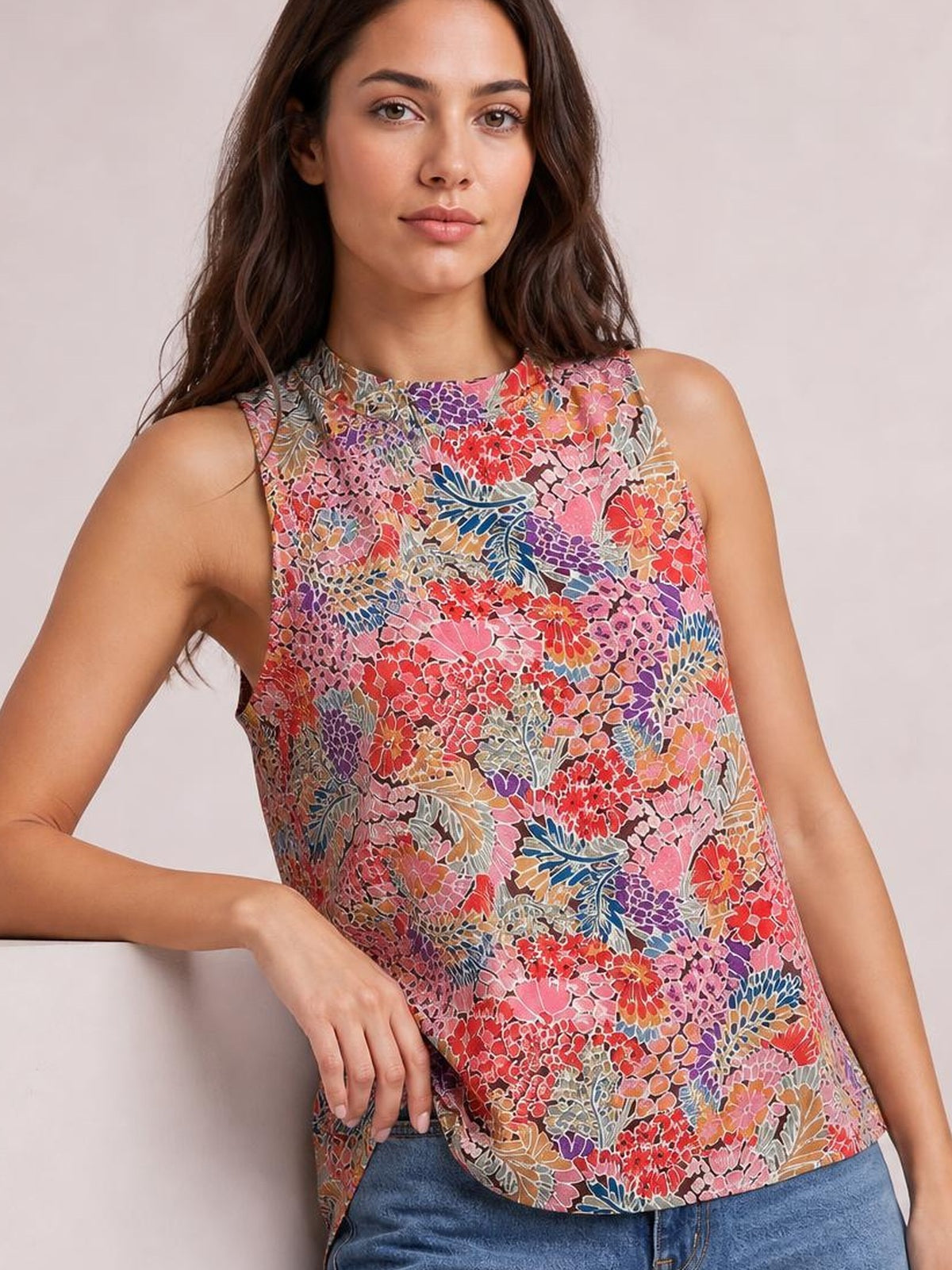 Model wearing a colorful floral mock neck tank top with a sleeveless cut, relaxed regular-length silhouette, and straight hem.