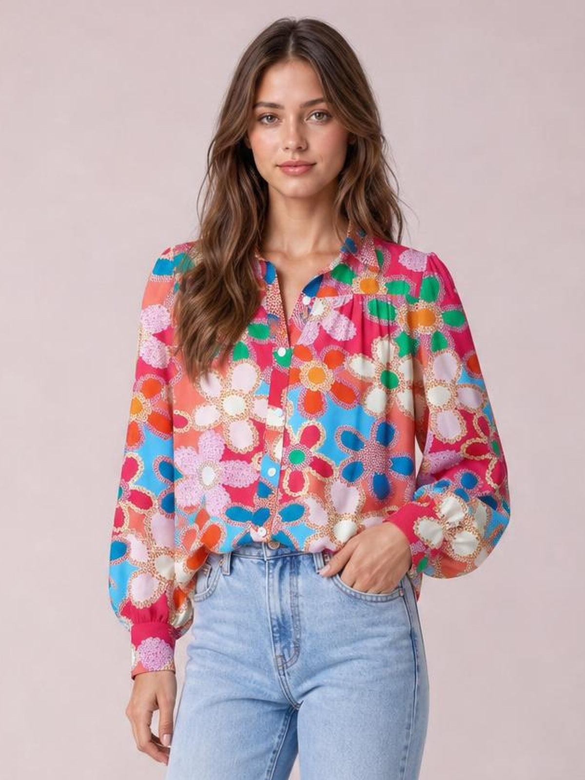 Model wearing a colorful floral print shirt with a collared neckline, button front, regular length, and voluminous lantern sleeves.