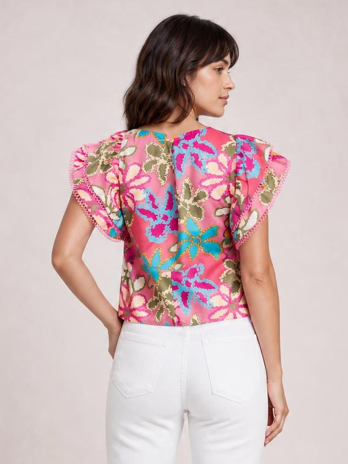 Model shown from the back in a pink floral print blouse with a round neck, regular silhouette, and short flutter sleeves with trimmed edges.