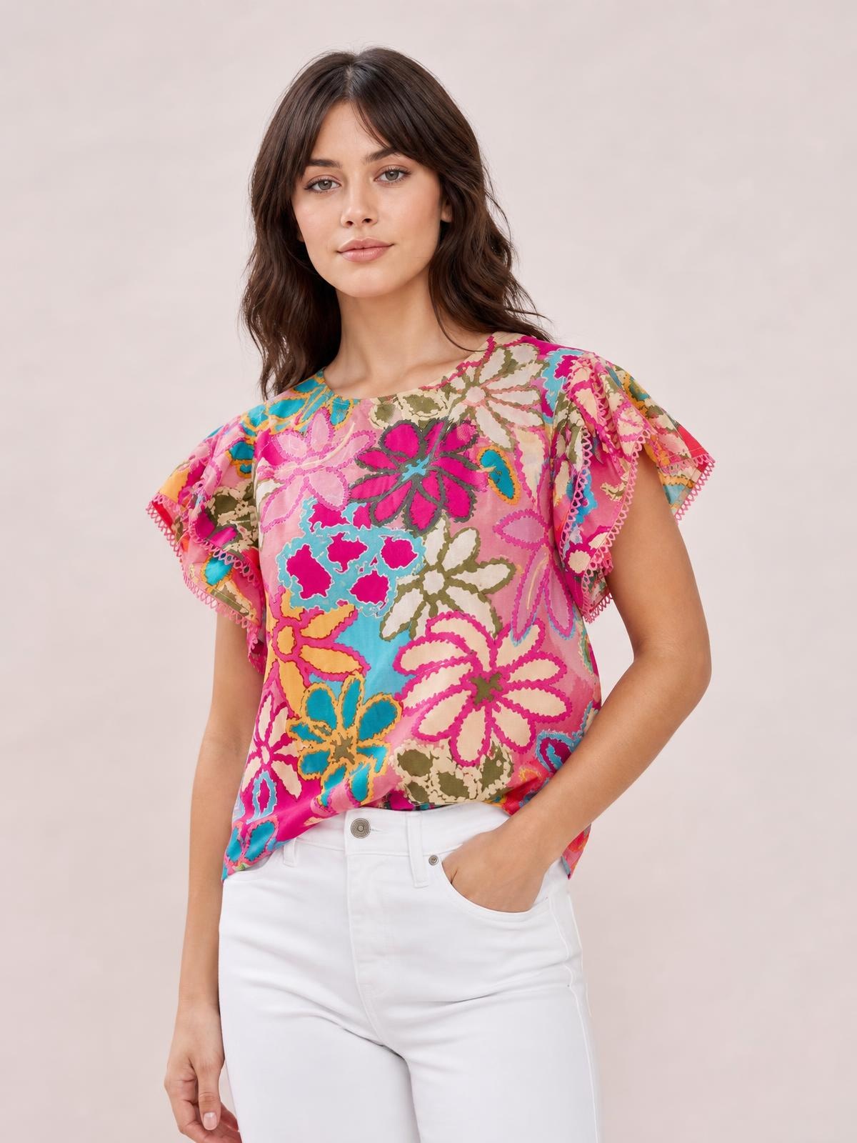 Model wearing a vibrant floral print blouse with a round neck, short flutter sleeves, regular silhouette, and decorative scalloped sleeve edges.
