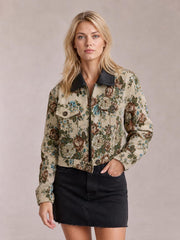 Model poses in a cropped floral print jacket with a black contrast collar, front zipper, buttoned flap pockets, and a relaxed boxy silhouette.