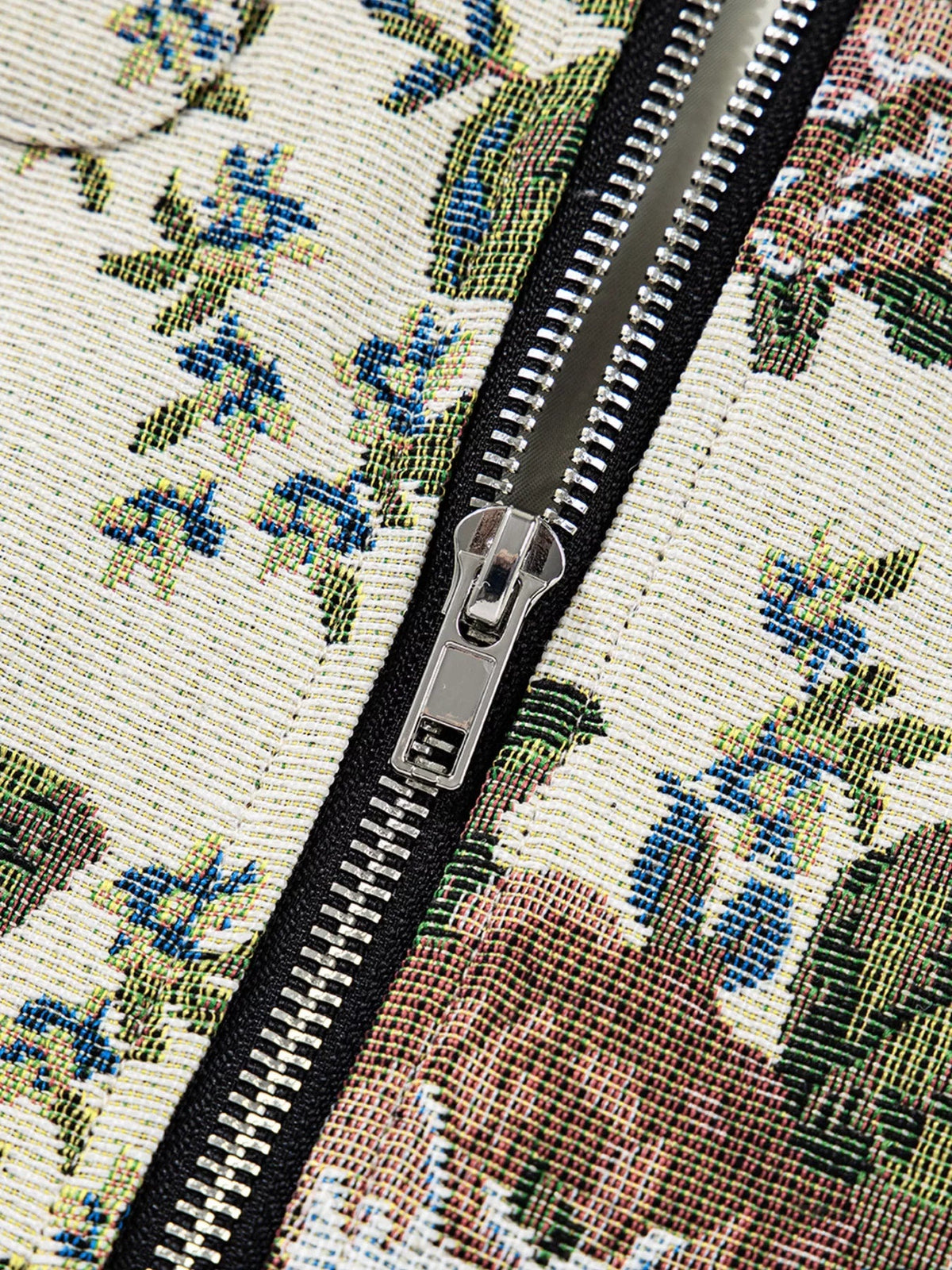 Close-up of the floral print jacket’s multicolor woven fabric, featuring a prominent black contrast panel and sturdy silver front zipper construction.