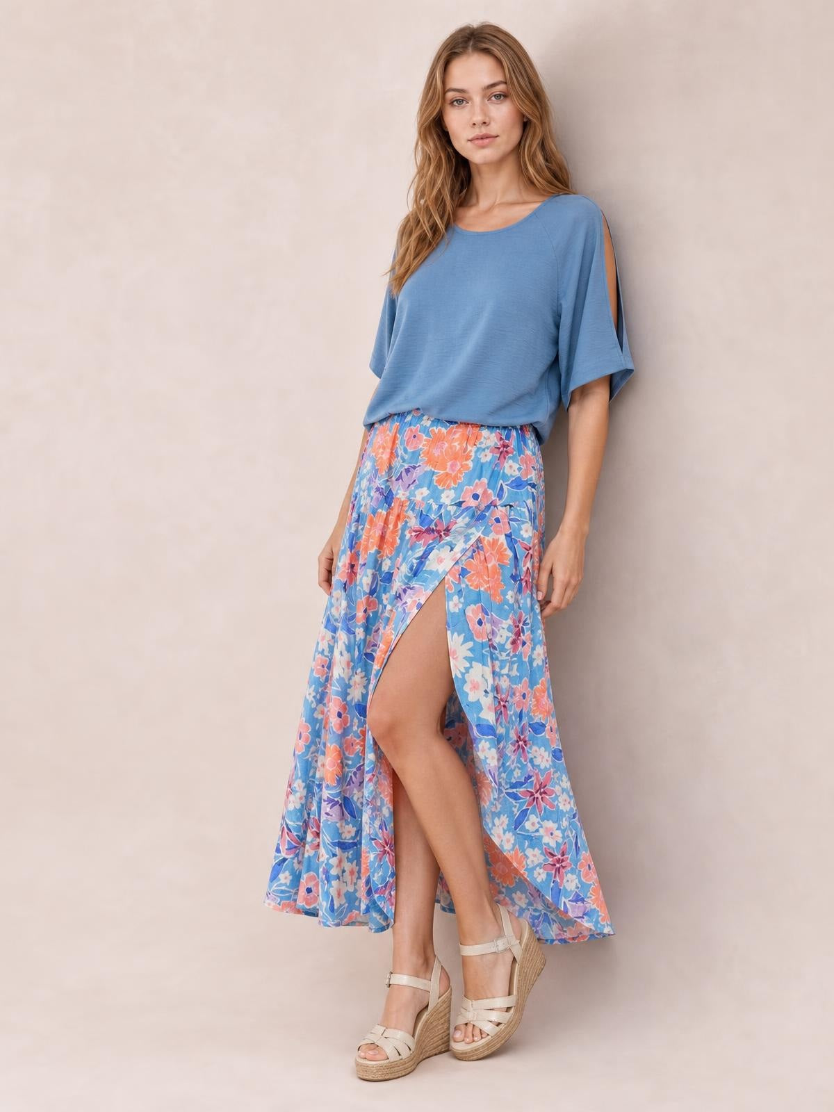 Model wearing a flowy blue floral printed high waist split skirt with a modern front slit and ankle-length silhouette.