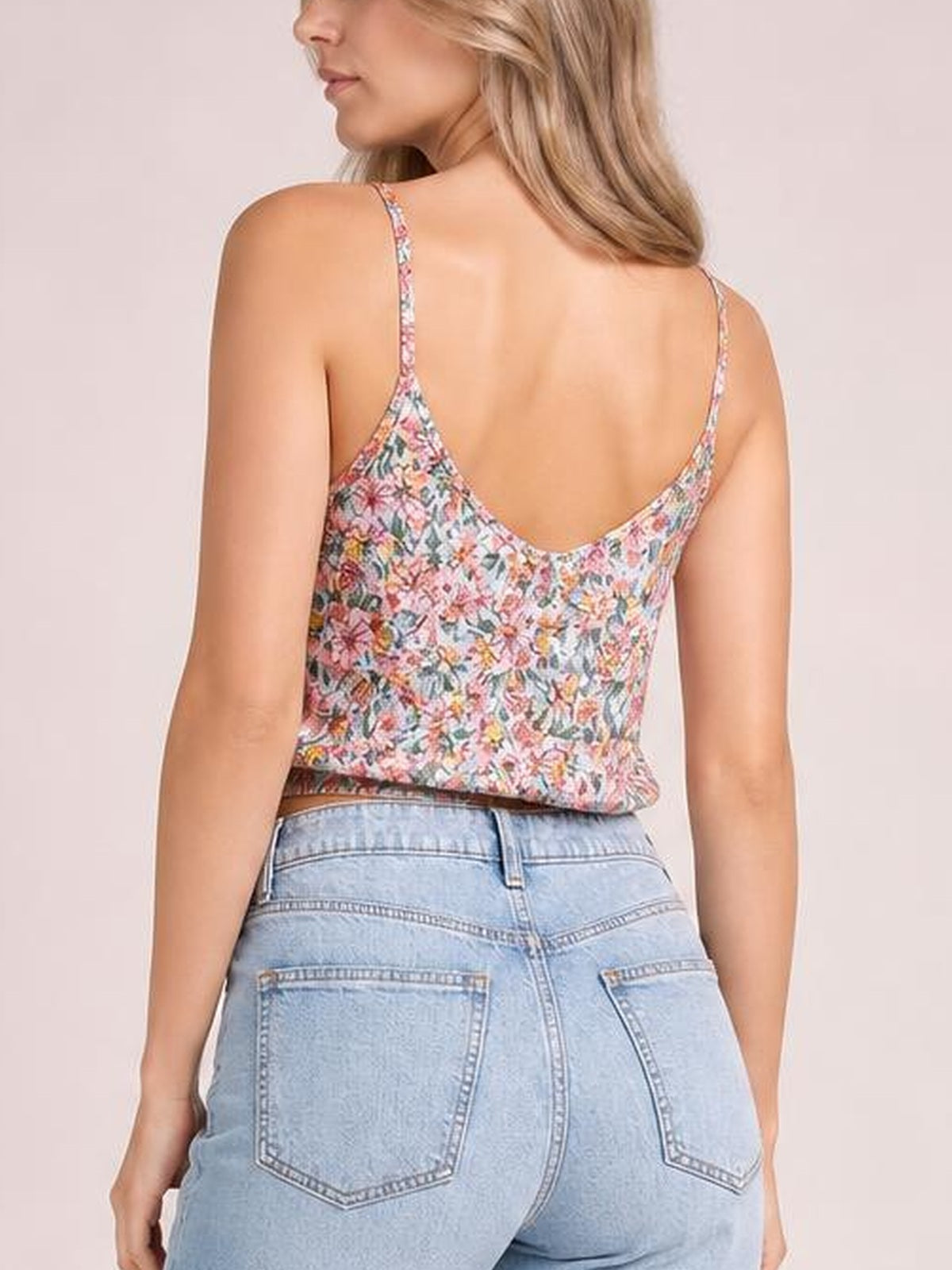 Model turned away wears a multicolor floral cami top with thin shoulder straps, a gently curved back neckline, and a relaxed regular-length silhouette.