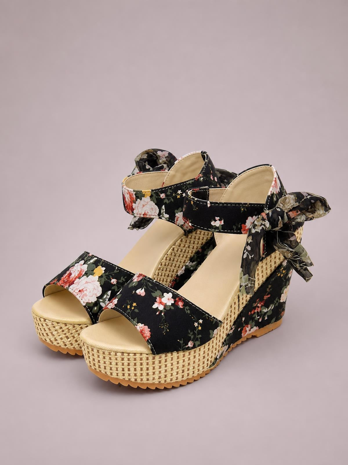 Black floral high heel sandals feature open toes, wide straps, ankle ties, and tall woven platform wedge soles.
