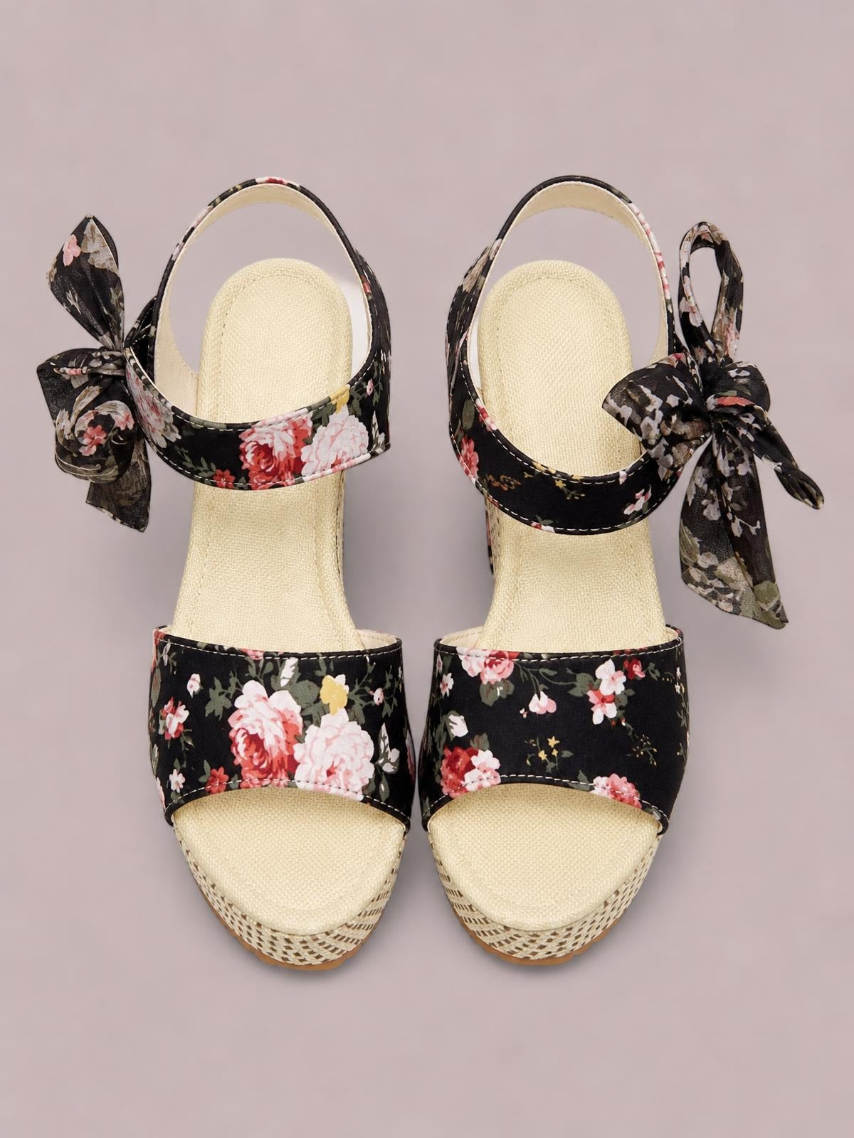 Black floral high heel sandals feature wide peep-toe straps, contrasting stitched edges, woven platform soles, and oversized ankle ties.