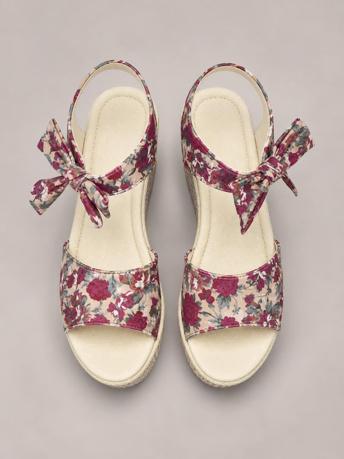 Floral-print high heel sandals with open toes, wide front straps, cream soles, and large tied ankle bows in burgundy, pink, blue, and beige.
