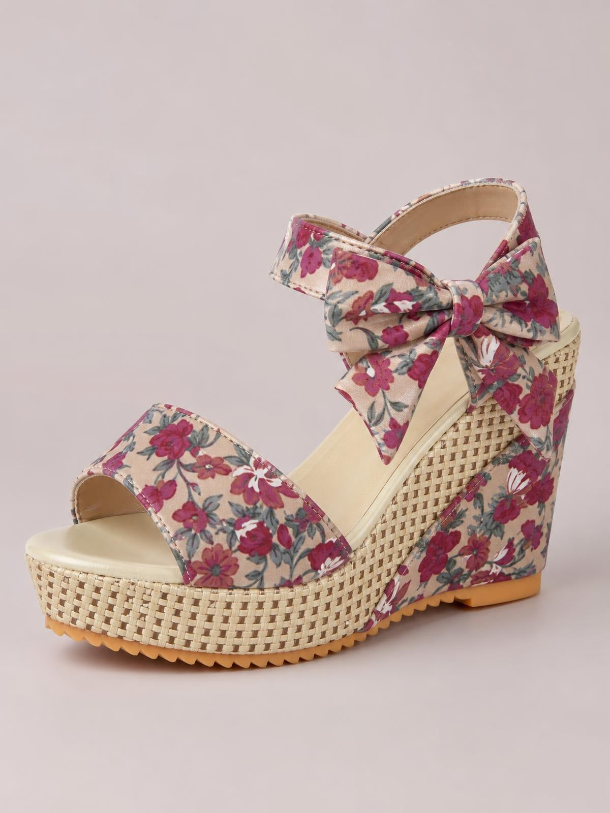 Floral tied high heel sandals in cream with burgundy flowers, open toes, oversized bow ankle straps, and woven platform wedge soles.