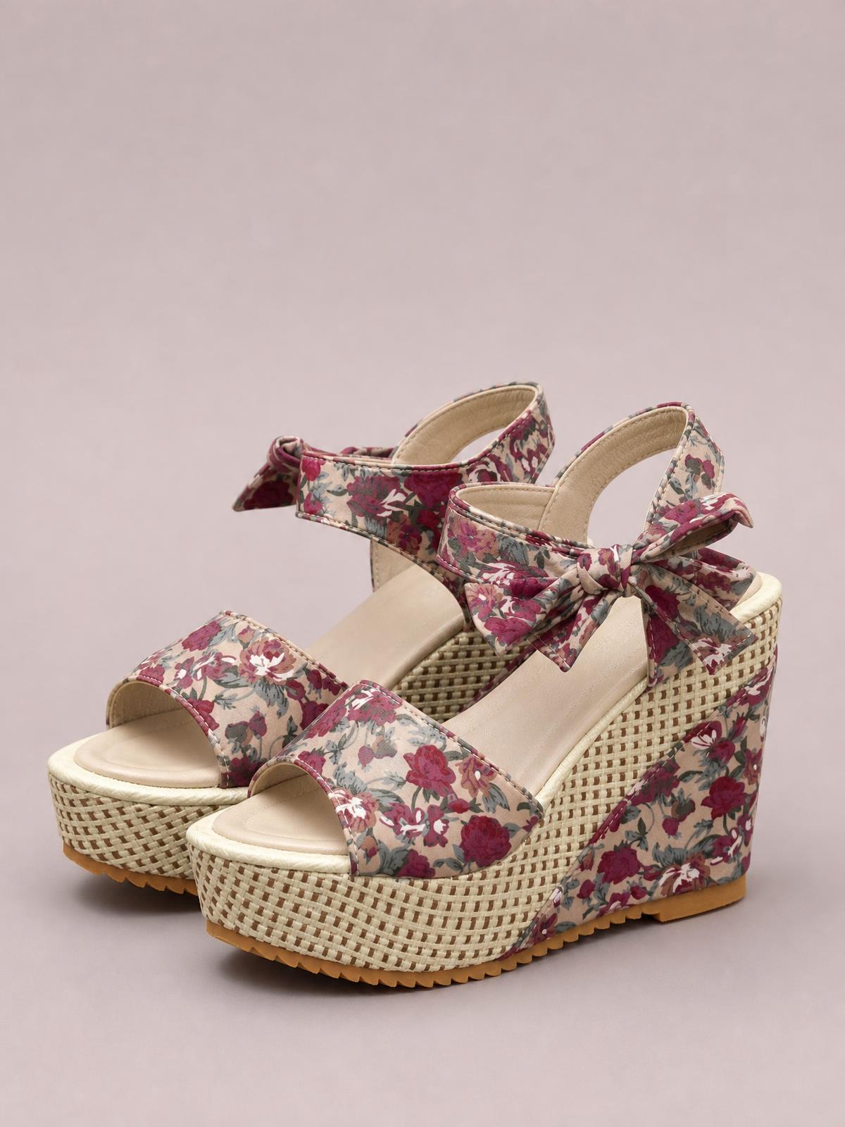 Floral tied high heel sandals feature burgundy and cream flower-print straps, open toes, bow ankle ties, and chunky woven wedge platforms.