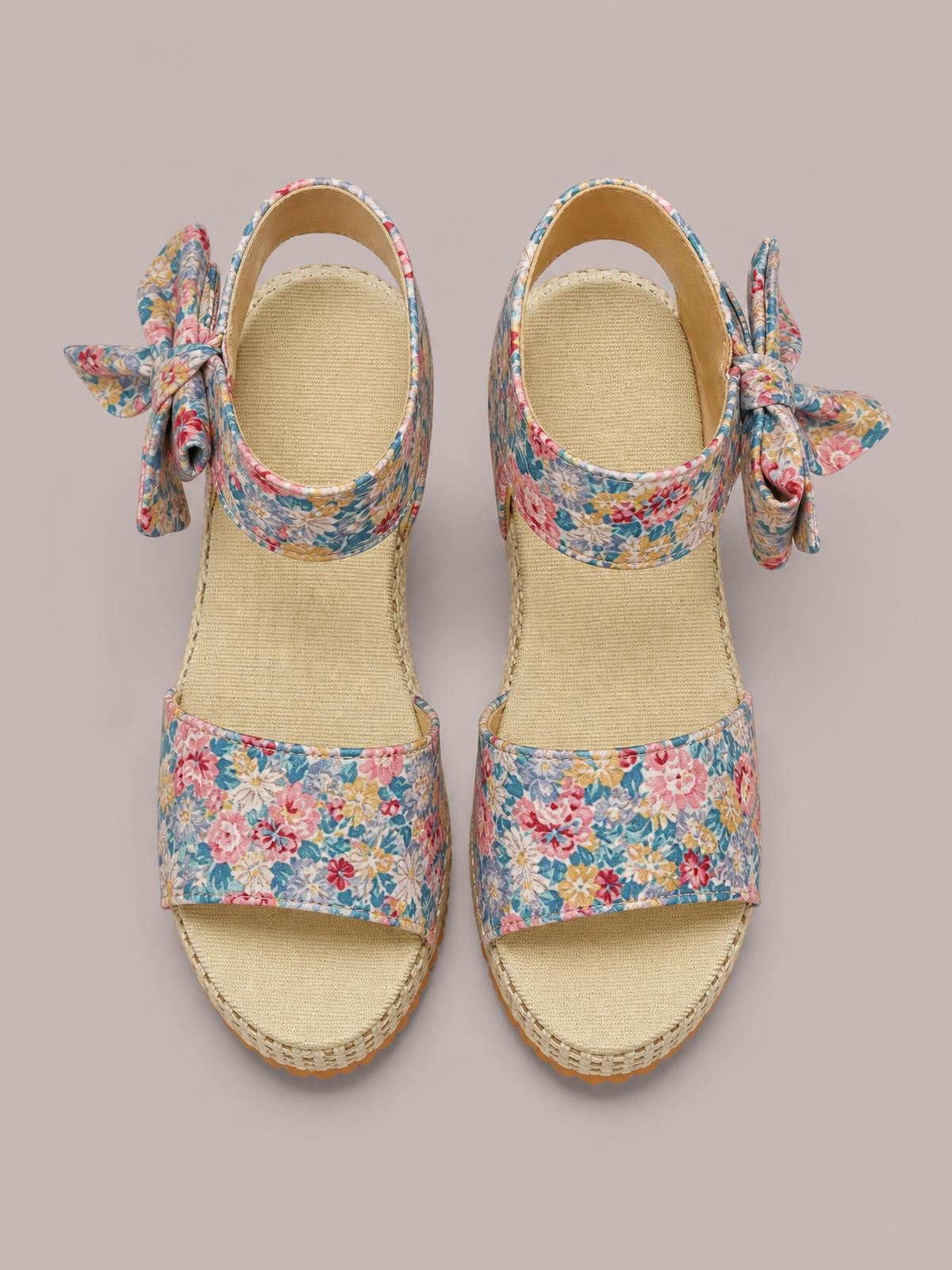 Floral high heel sandals feature colorful flower print straps, tied ankle bows, open toes, wide front bands, and textured espadrille-style wedge soles.