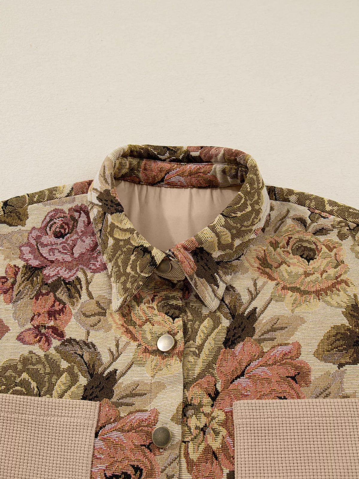 Floral patchwork jacket in muted beige, olive, and rose features a textured waffle-knit collar and chest pockets with a buttoned front.
