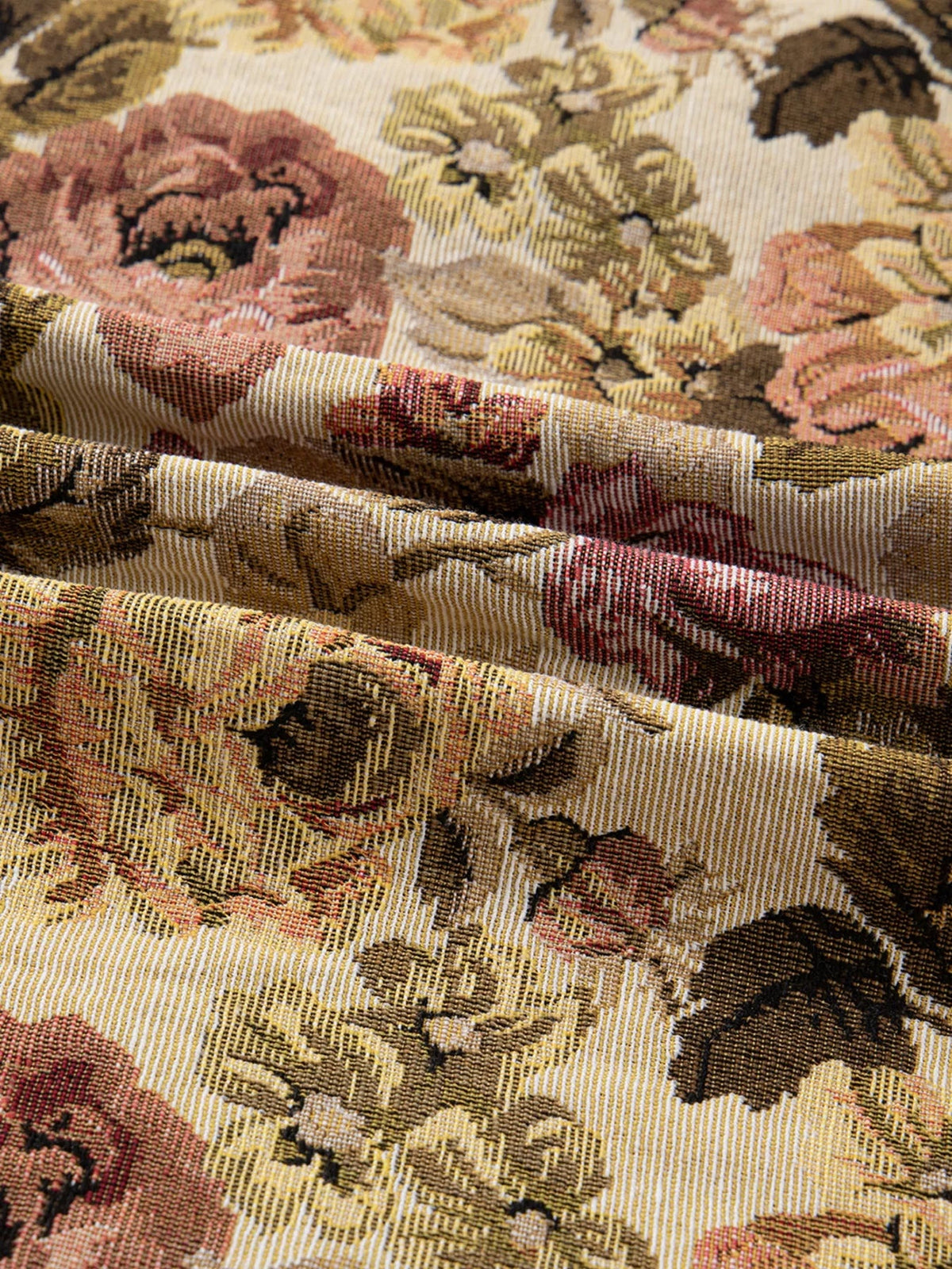 Close-up of the jacket’s floral fabric in cream, tan, burgundy, and black, showing a textured woven surface with layered folds.