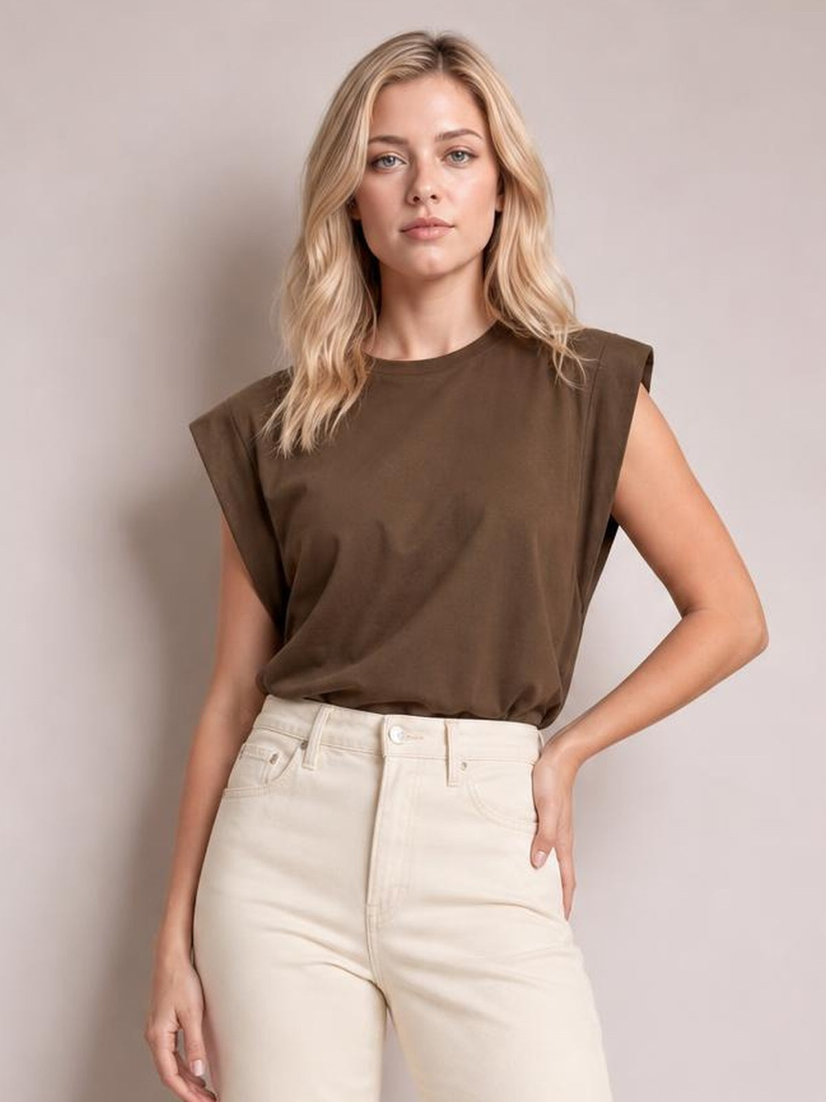 A woman models the brown Florira round neck cap sleeve T-shirt with a relaxed straight silhouette, soft drape, and slightly tucked hem.