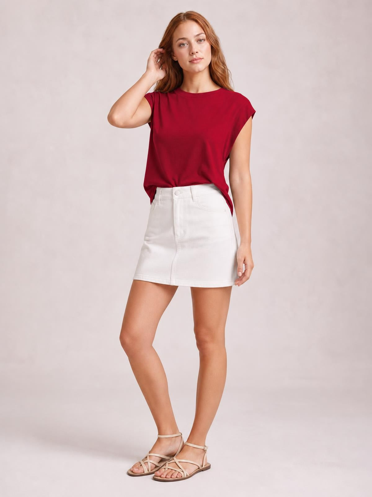 Model poses in a burgundy Florira round neck cap sleeve T-shirt with a relaxed silhouette and slightly stretchy opaque construction.