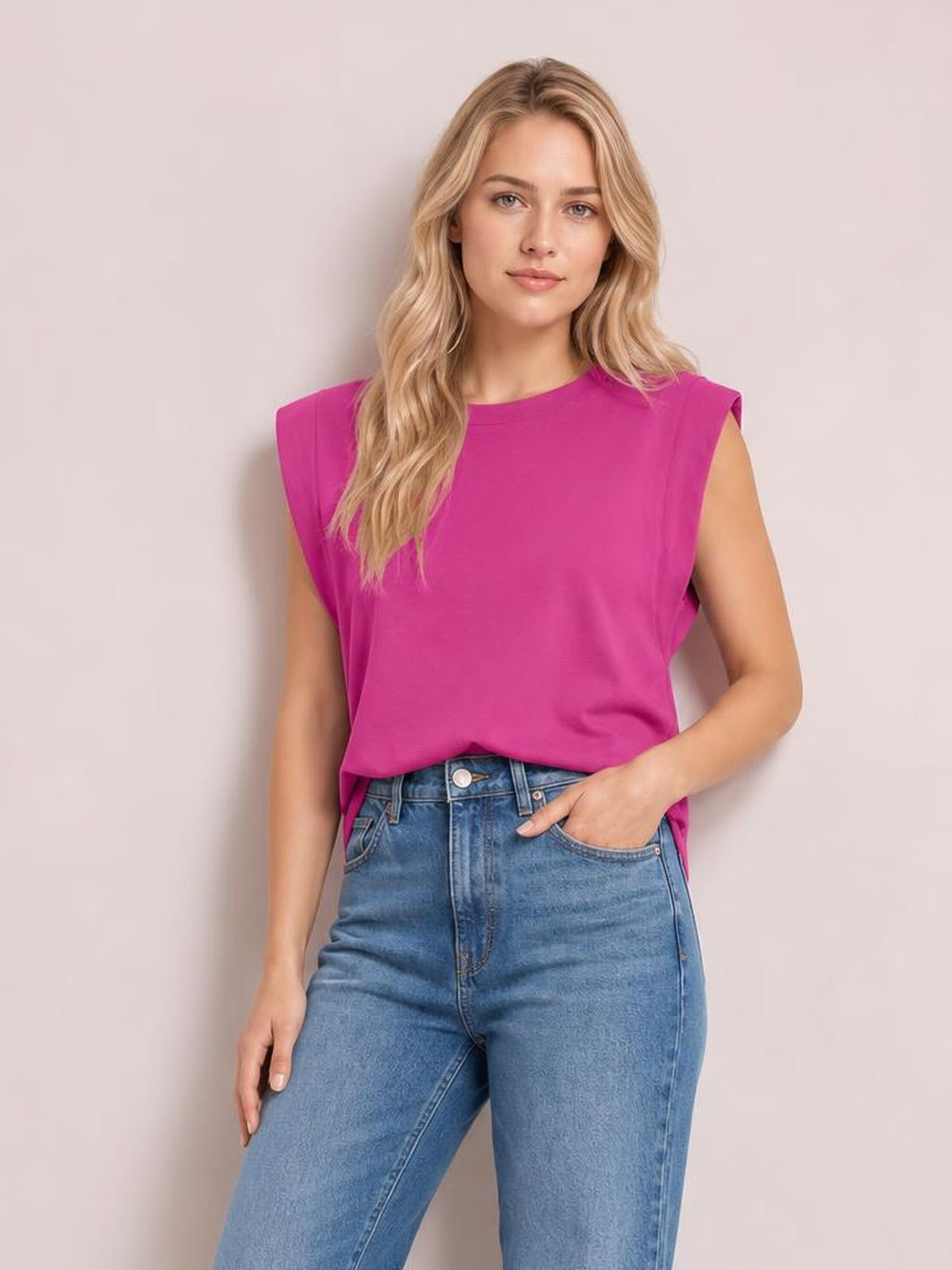 Model wears a bright pink Florira round neck cap sleeve T-shirt with a relaxed silhouette, standing with one hand in her jeans pocket.