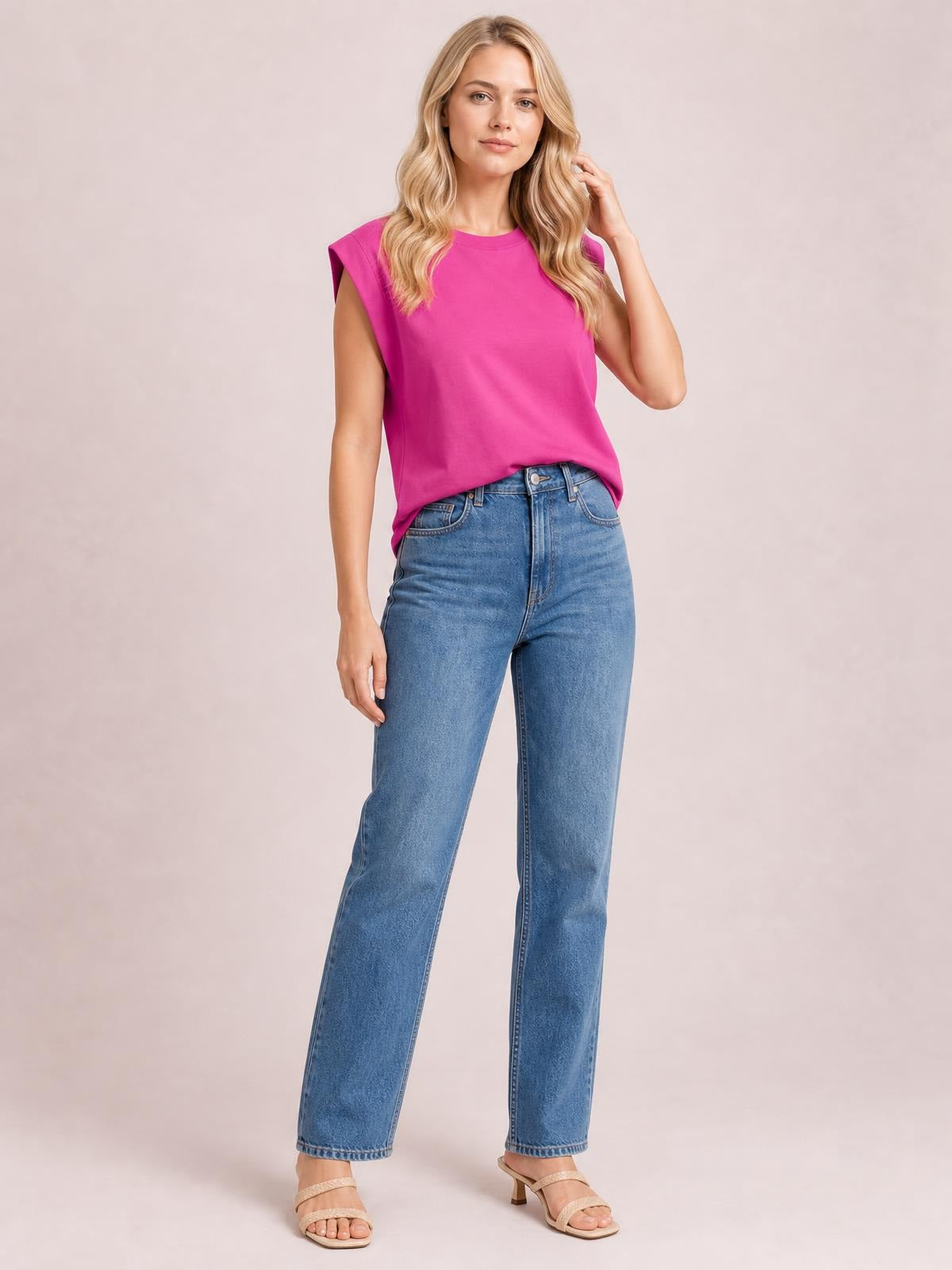 A model wears the pink Florira round neck cap sleeve T-shirt with a relaxed silhouette, slightly structured sleeves, and a casually tucked hem.