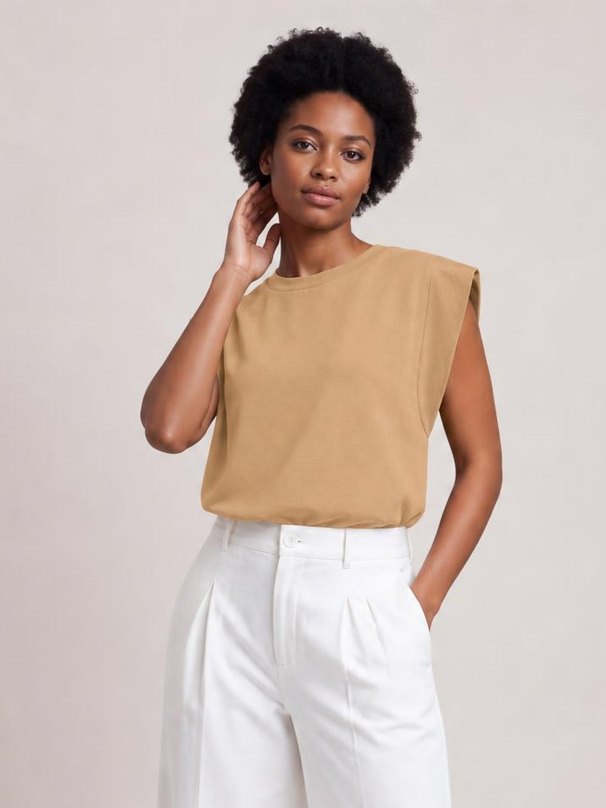 A model wears the tan Florira round neck cap sleeve T-shirt with a relaxed straight silhouette, smooth construction, and a slightly tucked hem.