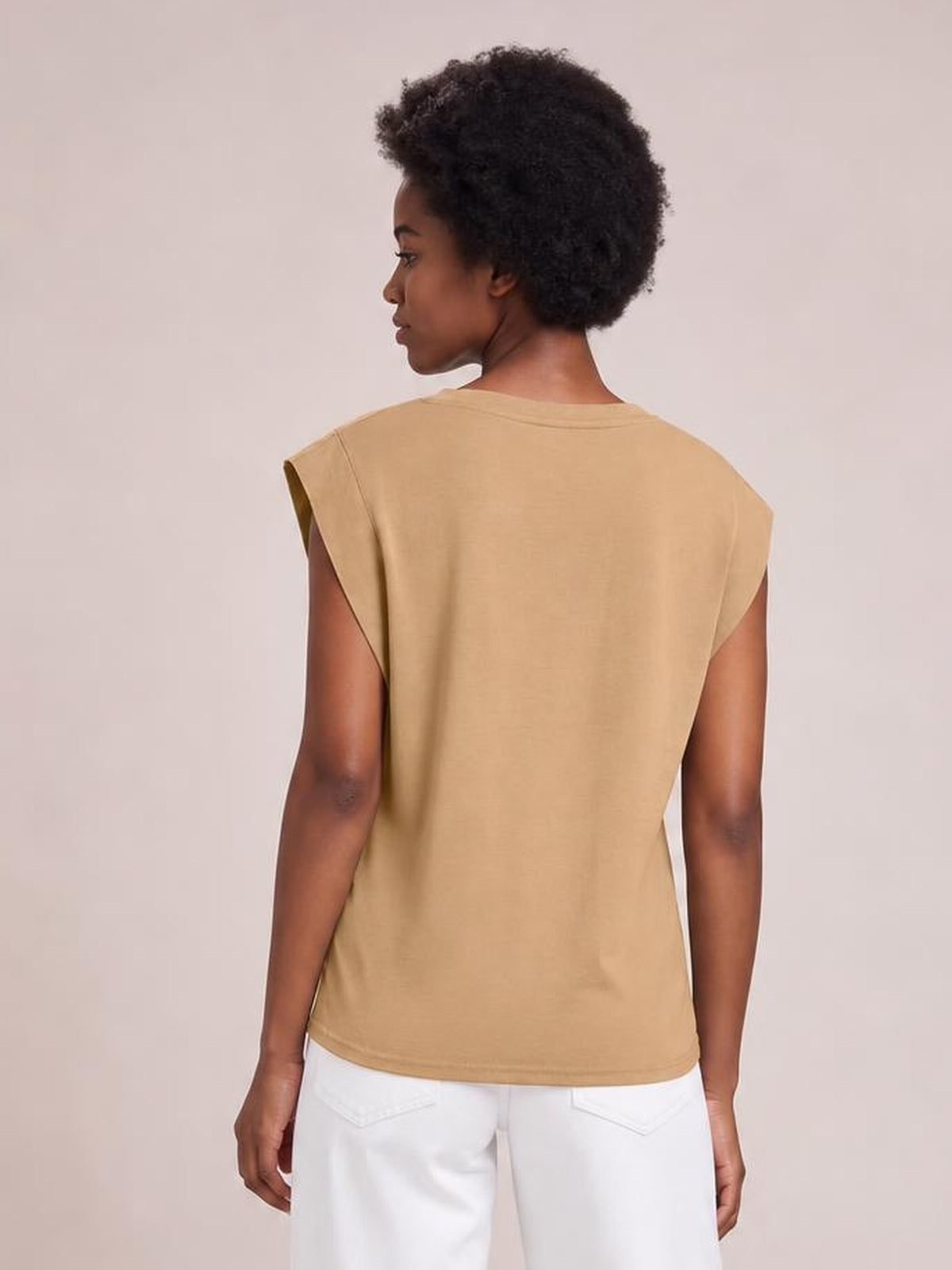 Model shown from the back wears a tan Florira round neck cap sleeve T-shirt with a relaxed, straight silhouette and clean opaque construction.