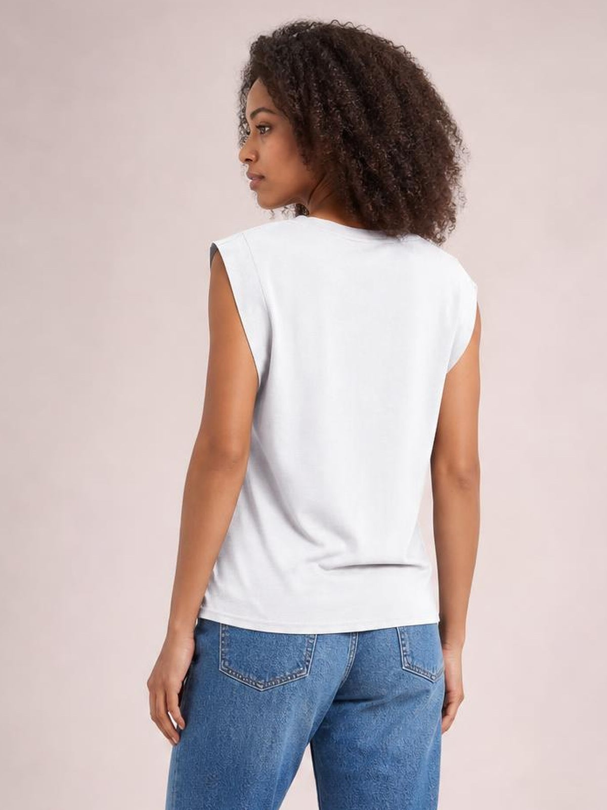 A model poses from the back in a white Florira round neck cap sleeve T-shirt with a relaxed, straight silhouette and clean hem.