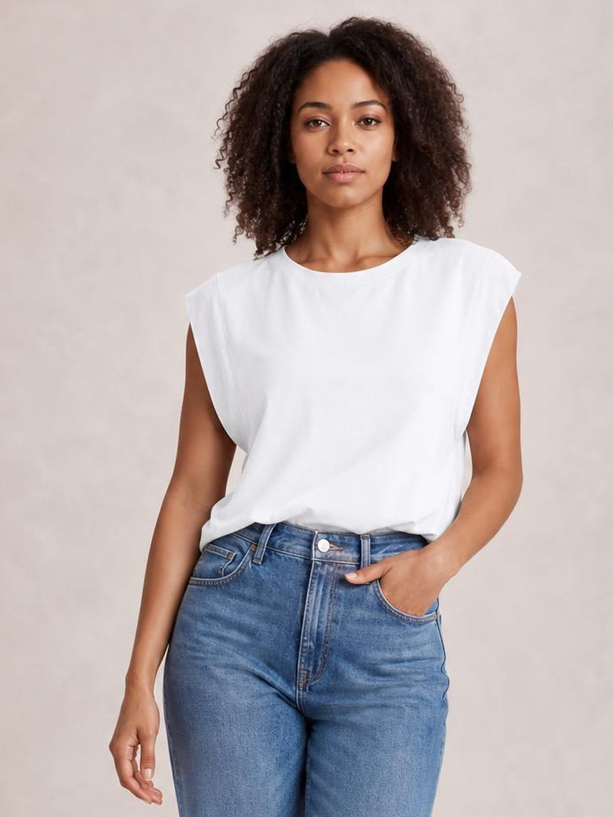 Model wears a white Florira round neck cap sleeve T-shirt with an opaque, relaxed silhouette, slightly stretchy construction, and a casually tucked hem.