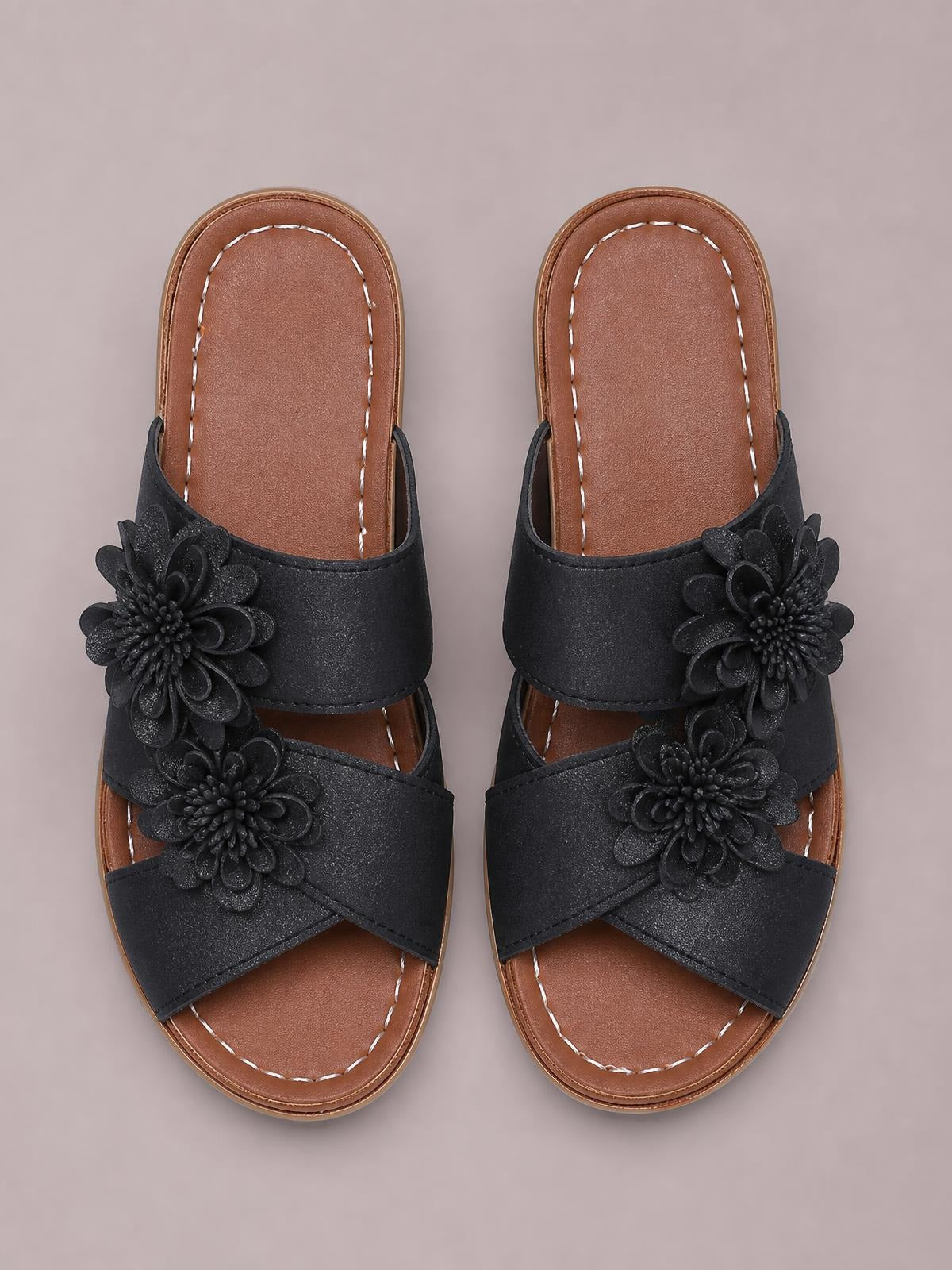 Black Flower Crisscross Wedge Sandals with layered floral appliqués, wide crossover straps, open toes, stitched brown insoles, and mid-height wedge heels.