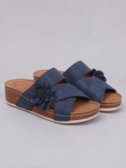 Navy Flower Crisscross Wedge Sandals feature broad overlapping straps, open toes, floral appliqués, and mid-height wedge heels with stitched platform soles.