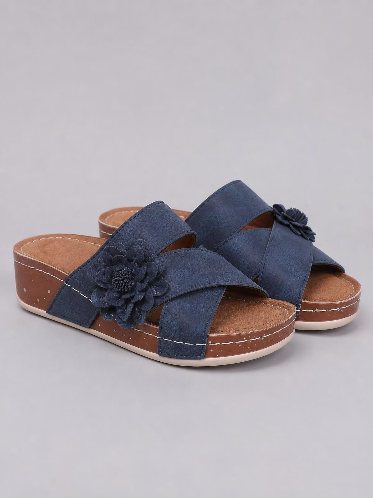 Navy Flower Crisscross Wedge Sandals feature broad overlapping straps, open toes, floral appliqués, and mid-height wedge heels with stitched platform soles.
