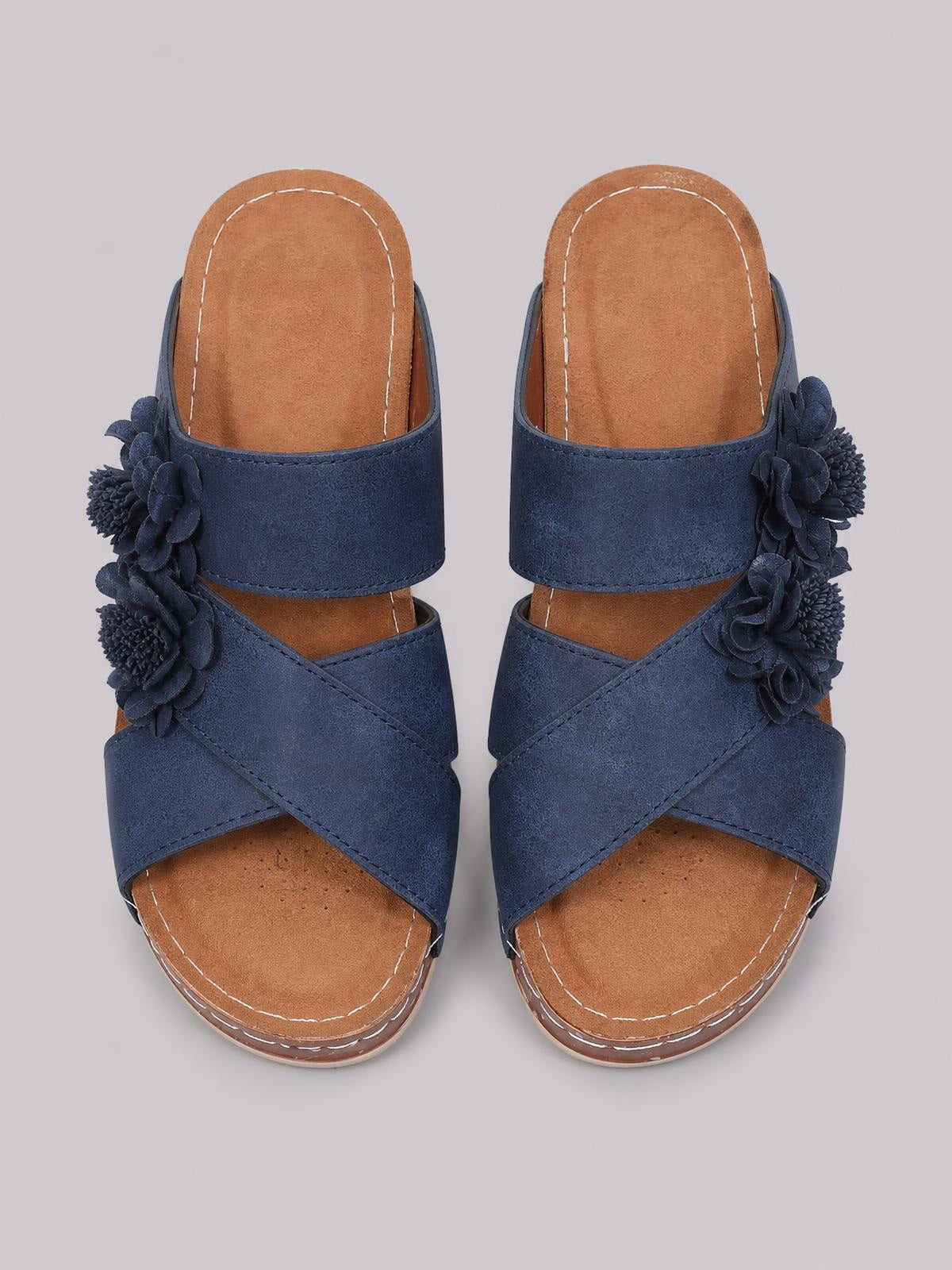 Navy Flower Crisscross Wedge Sandals feature open toes, layered crisscross straps, wide upper bands, floral side embellishments, and cushioned mid-height soles.
