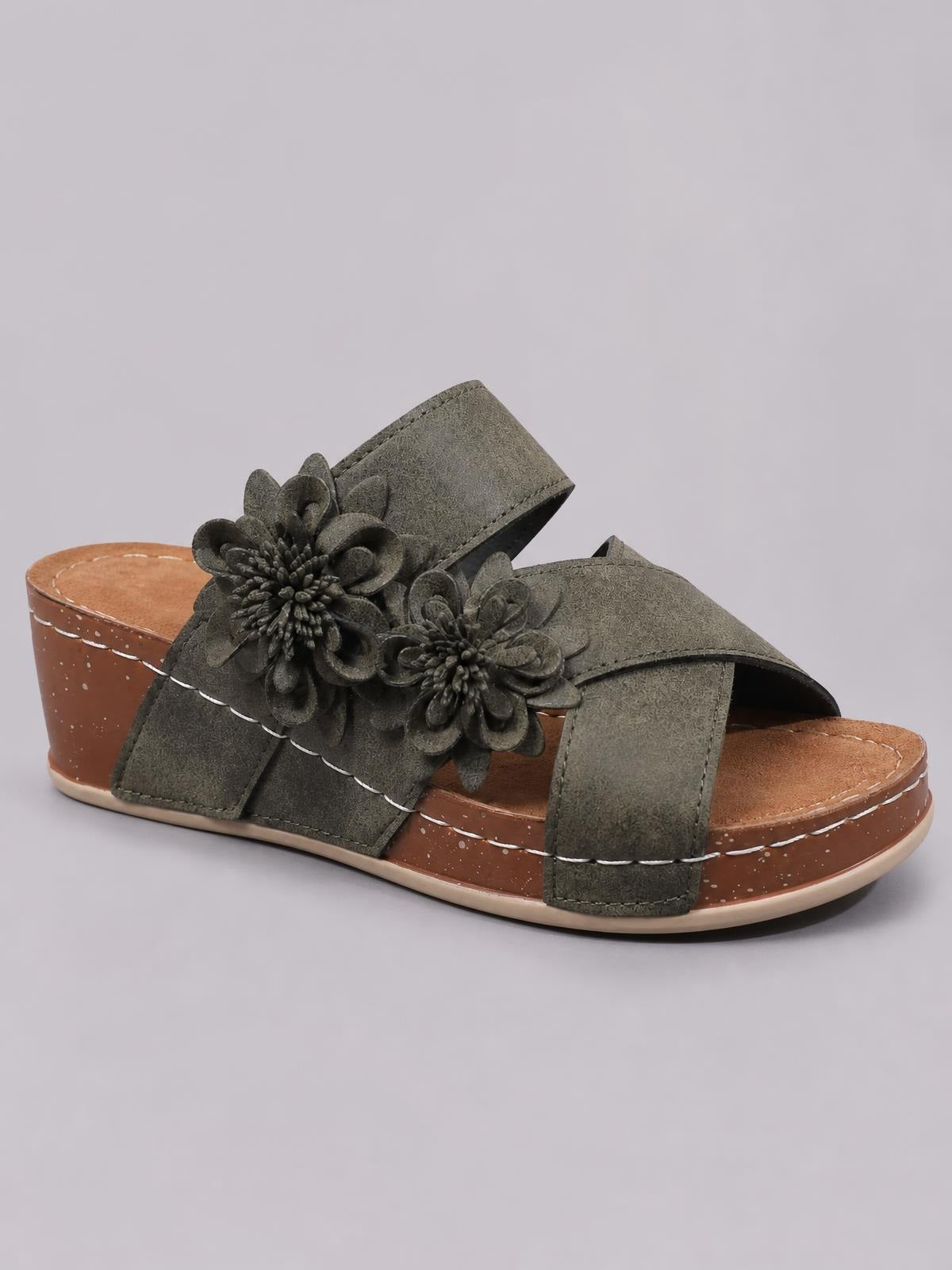 Olive-green crisscross wedge sandals feature open toes, layered flower appliqués, wide stitched straps, and a mid-height brown platform sole.
