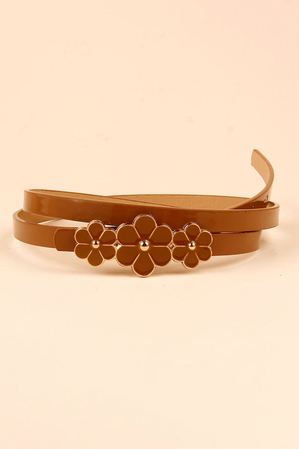 Slim brown PU belt with a polished finish, layered in a coil to show its narrow profile and clustered three-flower buckle construction.