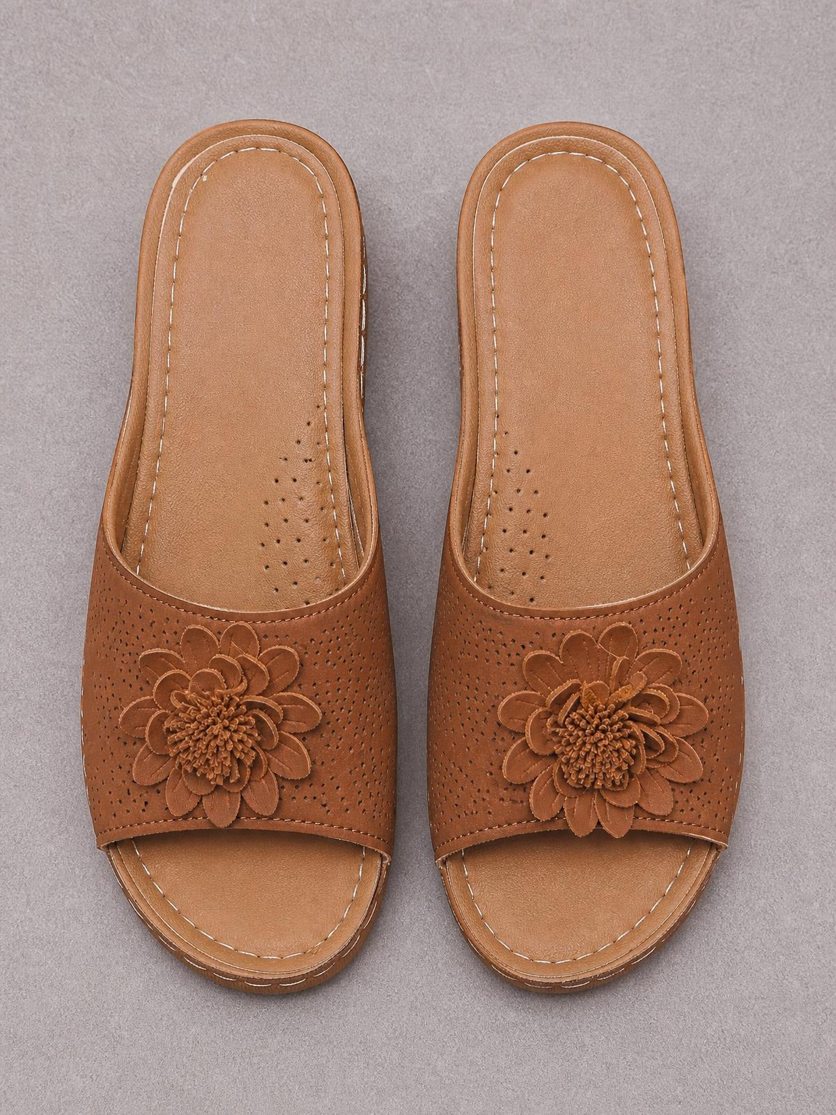 Brown flower peep-toe wedge sandals feature perforated PU leather uppers, layered floral appliqués, cushioned footbeds, and contrast stitching.