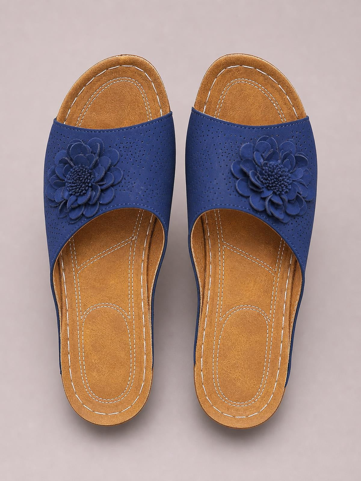 Blue peep-toe wedge sandals with perforated uppers, layered flower appliqués, contrast stitching, and tan cushioned footbeds.